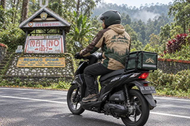 Visual kampanye driver Halo Malino berlatar monumen Malino